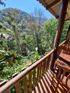 a balcony of a cabin with a view of the forest at Cabanas V 13, 2ª maior viaduto do mundo! Camping in Vespasiano Corrêa