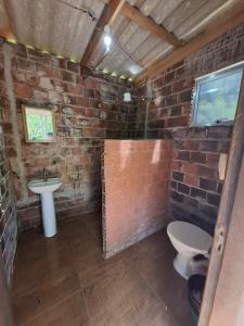 a brick walled bathroom with a toilet and a sink at Cabanas V 13, 2ª maior viaduto do mundo! Camping in Vespasiano Corrêa