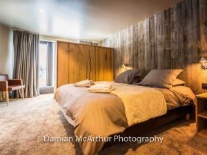 une chambre avec un grand lit avec un mur en bois dans l'établissement Loft duplex d'exception pour 12 pers à Avoriaz avec accès direct pistes et espace bien-être - FR-1-314-305, à Avoriaz 4 autres photos