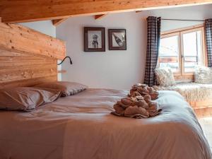 a large bed with a stuffed animal on top of it at Superbe chalet 5 chambres avec cheminée et accès privatif à Avoriaz - FR-1-314-161 in Morzine