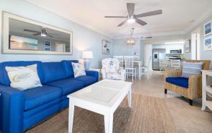 a living room with a blue couch and a table at Phoenix East 203 condo in Orange Beach