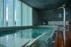 a large swimming pool with a chair in a building at Natalino Hotel Patagonia in Puerto Natales