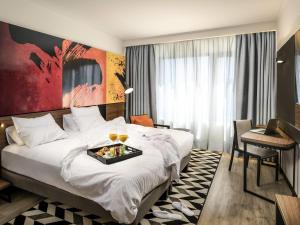 a hotel room with a bed with a tray of food on it at Novotel Santiago Providencia in Santiago +88 photos