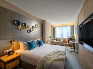 a hotel room with a large bed and a television at Novotel Melbourne Central in Melbourne