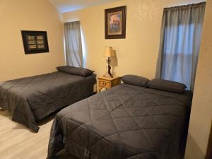 a hotel room with two beds and a lamp at Texas Star Lodges in Floresville