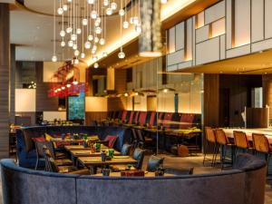 Un restaurante con mesas y sillas y una lámpara de araña. en Pullman Tokyo Tamachi, en Tokio
