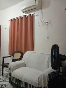a living room with a couch and a curtain at residência Cop 30 Belém do Pará in Belém