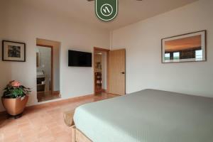 a bedroom with a bed and a tv on the wall at Centric 3BR Condo in Downtown in Oaxaca in Oaxaca City
