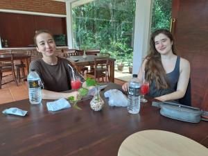 Un niño y una niña sentados en una mesa con bebidas. en Alankara Nature Resort, en Kitulgala