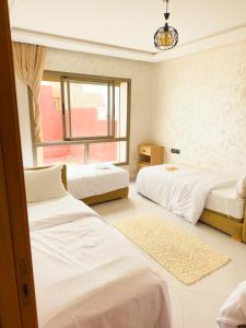 a bedroom with three beds and a window at Imsouane Sea surf in Imsouane