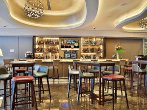 a bar in a restaurant with stools at Palladio Hotel Buenos Aires - MGallery Collection in Buenos Aires