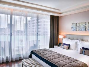 a hotel room with a bed and a large window at Palladio Hotel Buenos Aires - MGallery Collection in Buenos Aires