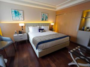a hotel room with a large bed and a chair at Palladio Hotel Buenos Aires - MGallery Collection in Buenos Aires +180 photos