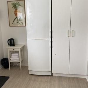 a large white refrigerator in a room with a table at Motel Egense in Storvorde