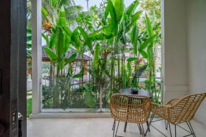 Un patio con dos sillas y una mesa y algunas plantas. en Work, Rest, Renew - Sarang Apartments 3 in Ubud, en Ubud