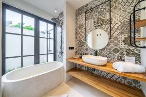 Un baño con bañera y una gran ventana. en Work, Rest, Renew - Sarang Apartments 3 in Ubud, en Ubud