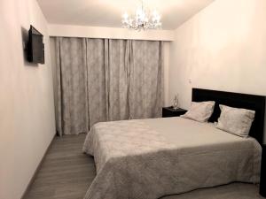 a bedroom with a large bed and a chandelier at Casa do Margalho in Miranda do Douro