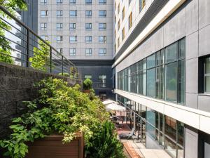 an internal courtyard of a building with plants at Novotel Almaty City Center in Almaty