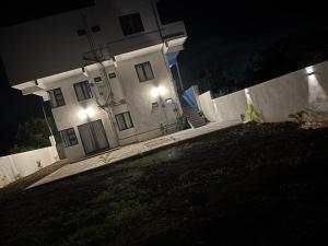 a white house with two lights on a fence at night at The Palms Property in Long Mountain