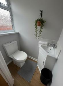Un baño blanco con inodoro y lavabo. en Bungalow - Contractors Welcome, en Farnborough 1 foto más