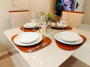 a table with plates and wine glasses on it at Conforto & Estilo - Shows - Turismo - Negocios by Capta Stays in Belém