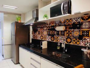 a kitchen with a black counter top and a refrigerator at Conforto & Estilo - Shows - Turismo - Negocios by Capta Stays in Belém