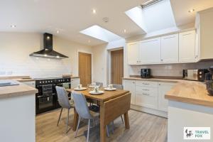 Una cocina con una mesa y sillas de madera. en Pear Tree Cottage Pool Table 15mins drive to Alton Towers, en Denstone