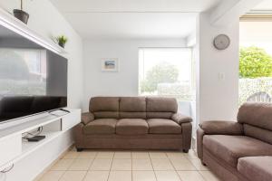 een woonkamer met een bank en een tv bij Isla Bonita Townhouse - 5 min SJU in Carolina