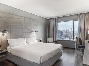 a hotel room with a bed and a large window at Pullman Santiago Vitacura in Santiago +178 photos