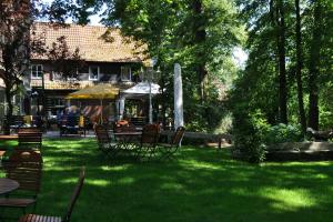 a yard with a table and chairs and an umbrella at Hotel Restaurant Große Teichsmühle in Dülmen
