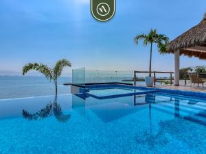 a swimming pool with a view of the ocean at Luxury Oceanfront 3 BR Condo with Balcony in Cruz de Huanacaxtle