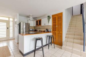 een keuken met een aanrecht en krukken in een kamer bij Isla Bonita Townhouse - 5 min SJU in Carolina