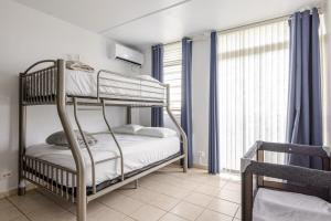 een slaapkamer met twee stapelbedden en een raam bij Isla Bonita Townhouse - 5 min SJU in Carolina +33 foto's