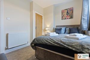 Un dormitorio con una cama con toallas. en Pear Tree Cottage Pool Table 15mins drive to Alton Towers, en Denstone