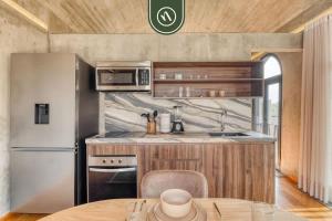 een keuken met een roestvrijstalen koelkast en een tafel bij Luxury 3 BR House in Downtown - AC - Peaceful in Oaxaca City +45 foto's