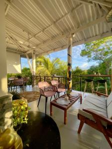 a patio with chairs and a table and a porch at Habibi Hostel & Restaurant in Unawatuna