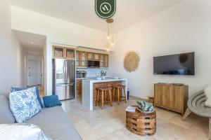 a living room with a couch and a kitchen at Oceanview Condo in Cabo with Beach - Pool in El Tule