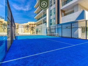 a tennis court in front of a building at 2BR Condo with Private Balcony - Padel Court in Nuevo Nayarit