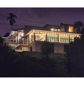 een groot huis met 's nachts licht bij Finca Hotel Gudys in Estación Belmonte