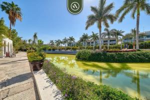 een resort met palmbomen en een vijver bij Amazing 2BR Condo in Nuevo Vallarta - Pool - King in Nuevo Nayarit