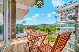 a balcony with a wooden table and two chairs at 2BR Condo with Private Balcony - Padel Court in Nuevo Nayarit