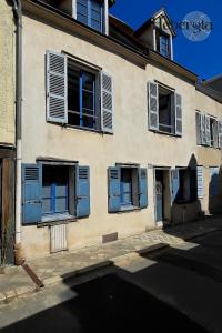 ein altes Gebäude mit blauen Fensterläden an einer Straße in der Unterkunft Maison basse-ville - centre historique in Chartres