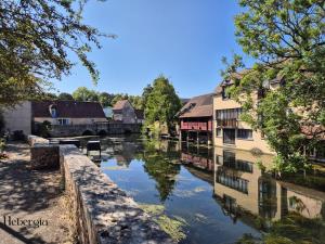 ein Fluss in einer Stadt mit Gebäuden und einer Brücke in der Unterkunft Maison basse-ville - centre historique in Chartres