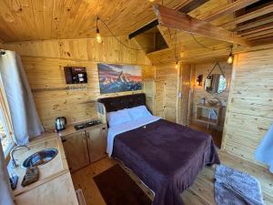 a bedroom with a bed in a wooden cabin at Pousada e Camping do Motochileiro in Urubici +33 photos