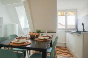 a dining room with a table with plates and wine glasses at Charme et confort au coeur de Mulhouse - Dolce Vita in Mulhouse