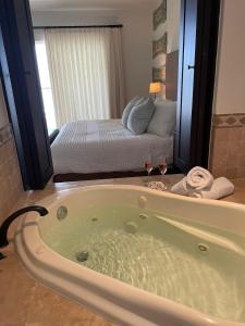 a bath tub with two wine glasses in a bedroom at Tortuga Bay TBB 2502 in San José del Cabo