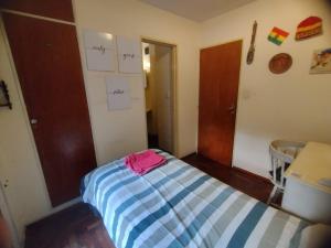 a small bedroom with a bed in a room with notes on the wall at Habitación single con baño privado en departamento compartido in Cordoba