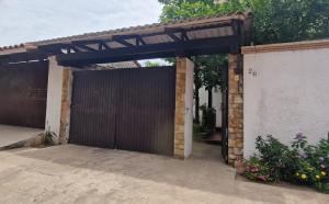 a garage with a wooden gate and a fence at Villa flor in Santa Cruz de la Sierra +2 photos