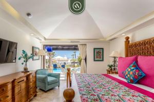 a bedroom with a bed and a tv and a chair at Amazing Villa with 3BR - Private Pool in El Tule