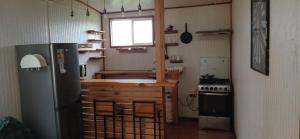 a small kitchen with a refrigerator and a stove at Cabañas fariña llanquihue in Llanquihue